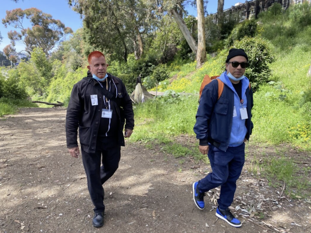 Two medical workers walk on a trail