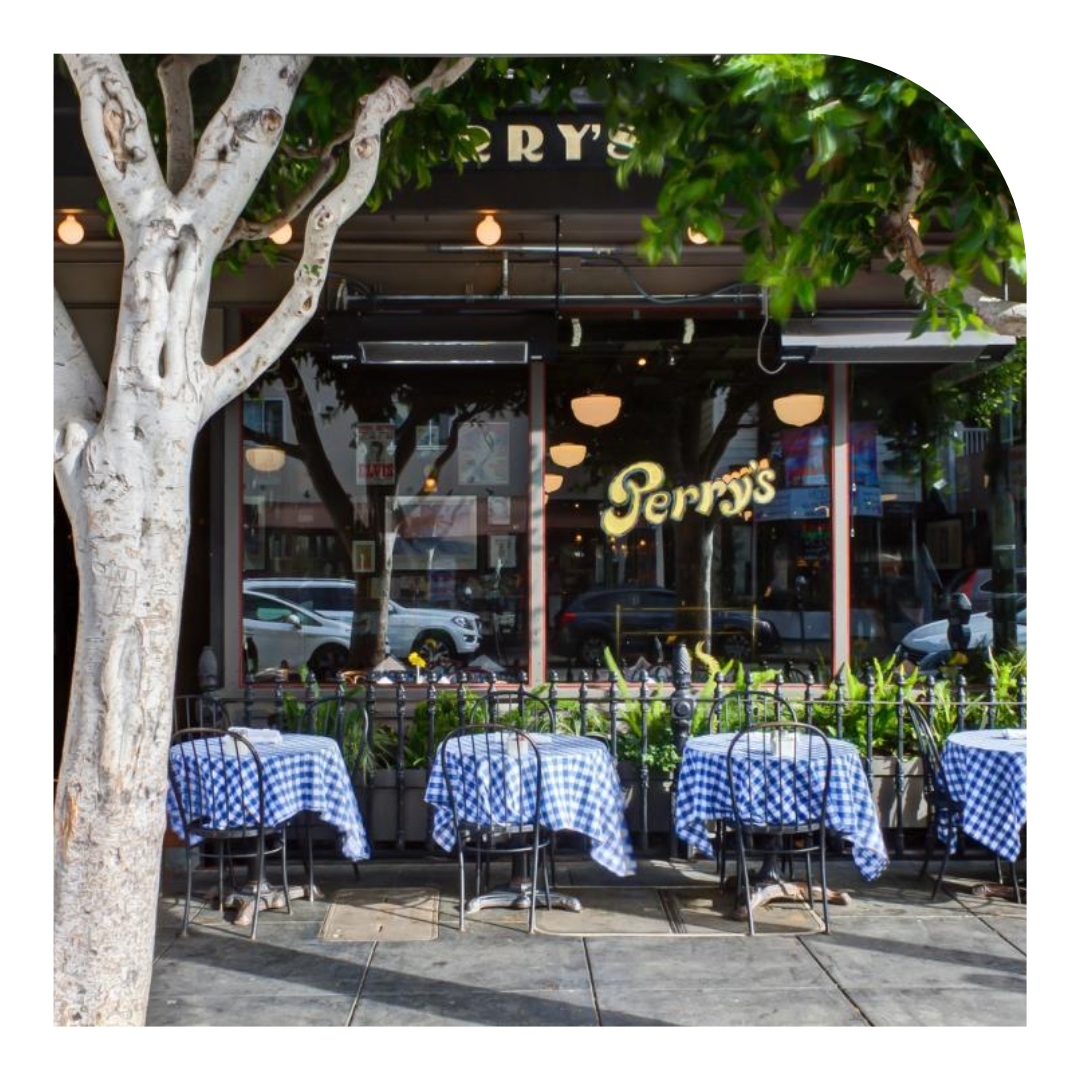 photo of the exterior of a restaurant with tables with blue tablecloths
