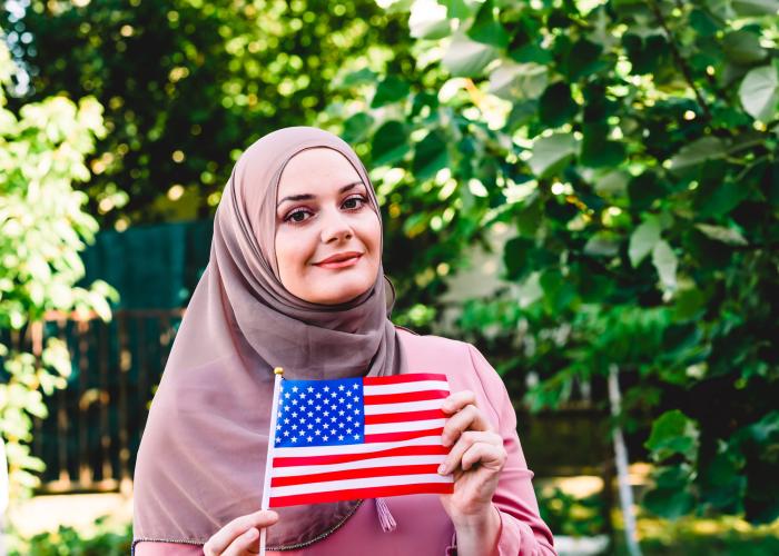 New U.S. citizen holds flag and smiles 