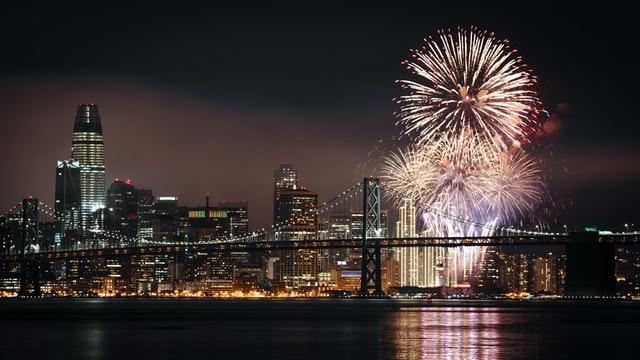 New Year's Eve fireworks are seen at night, along the San Francisco waterfront in front of the city lights.