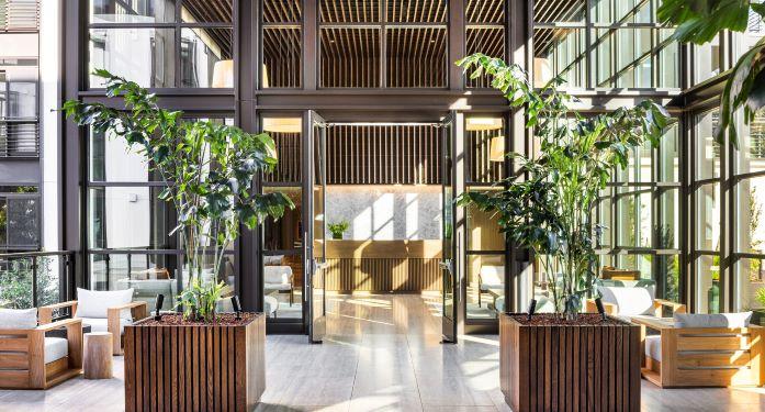 Image of the lobby exterior of the Bristol residence on Yerba Buena Island.  There is furniture and potted plants in the lobby space.