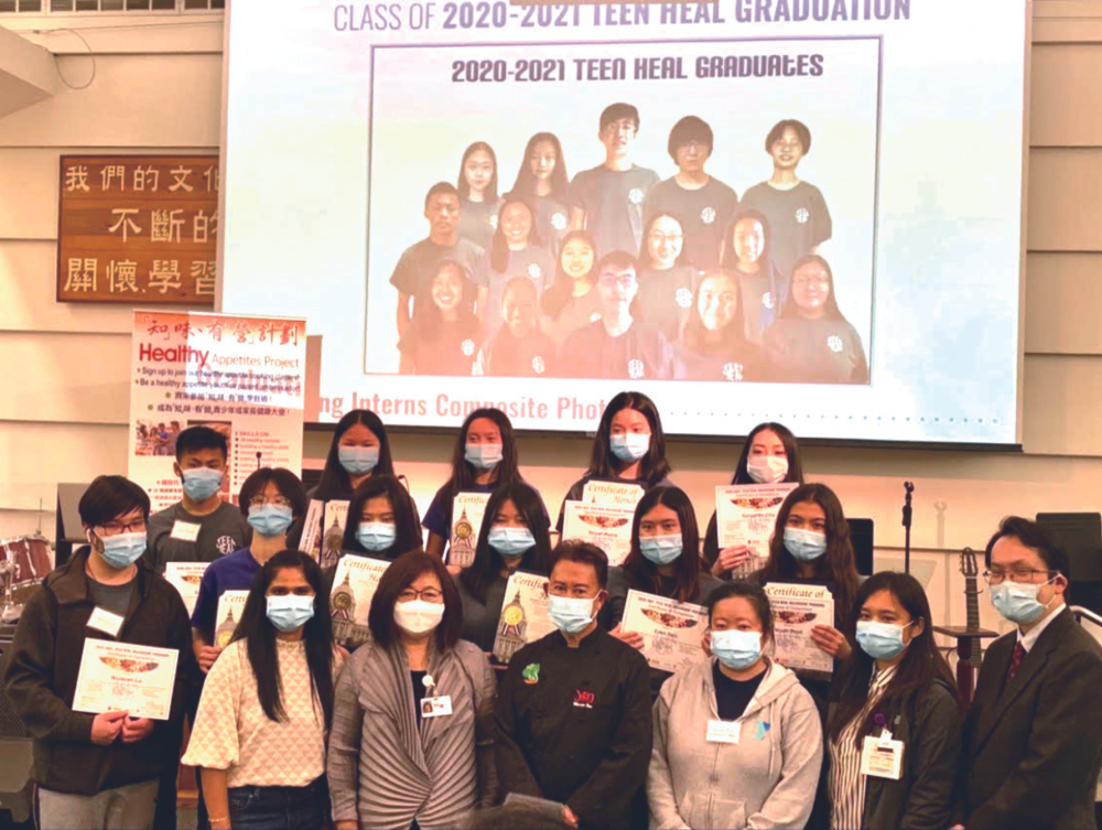 A group of teenagers who are part of the Chinatown Public Health Center's nutrition internship pose at their program graduation with adult leaders.